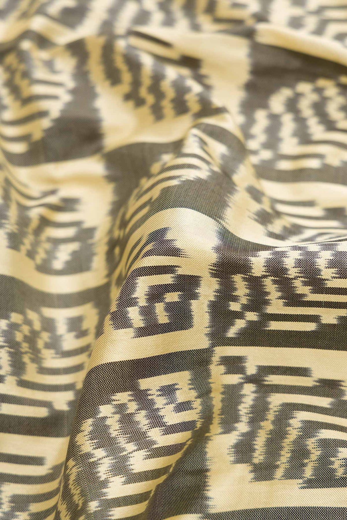 Close up of Sandal Pochampally Silk Saree with Pure Ikat on the body and Zari Border displaying folds