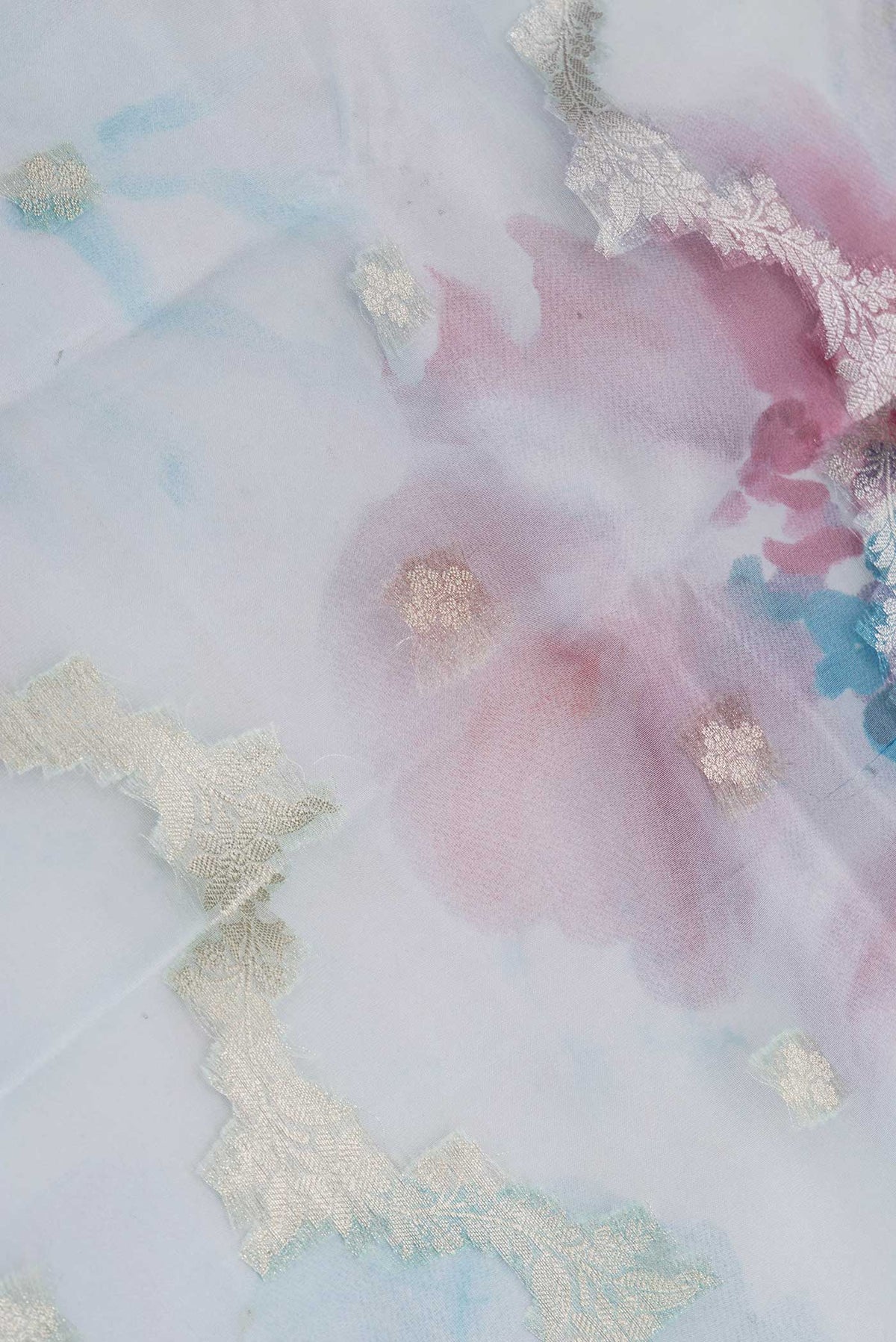 Close up of Sky Blue Dual Tone Organza Silk Saree with Zari Butta on the body and Zari Border displaying folds