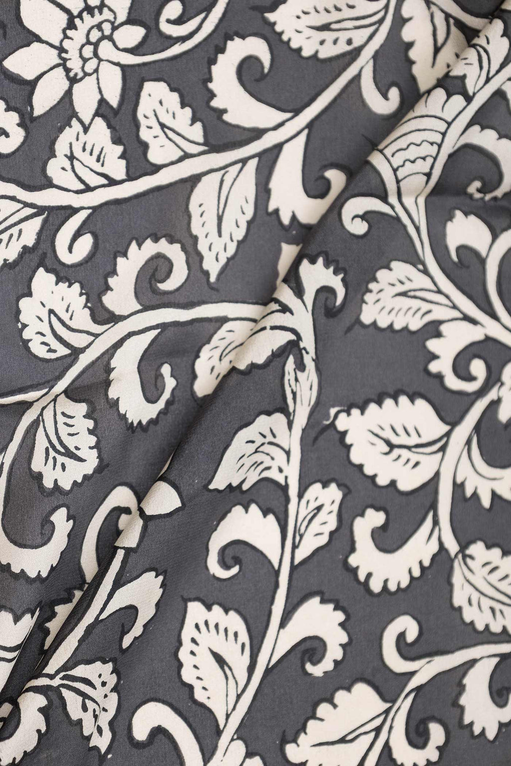 Close up of Grey Dual Tone Mysore Crepe Saree with Printed design on the body and Zari Border displaying folds