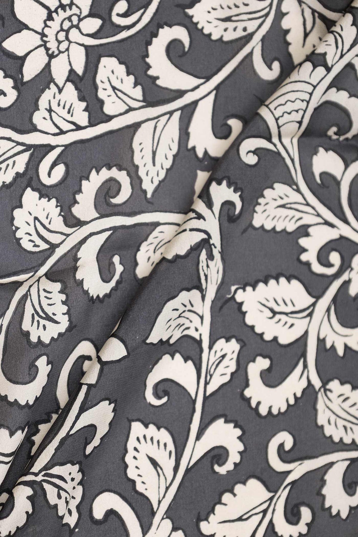 Close up of Grey Dual Tone Mysore Crepe Saree with Printed design on the body and Zari Border displaying folds