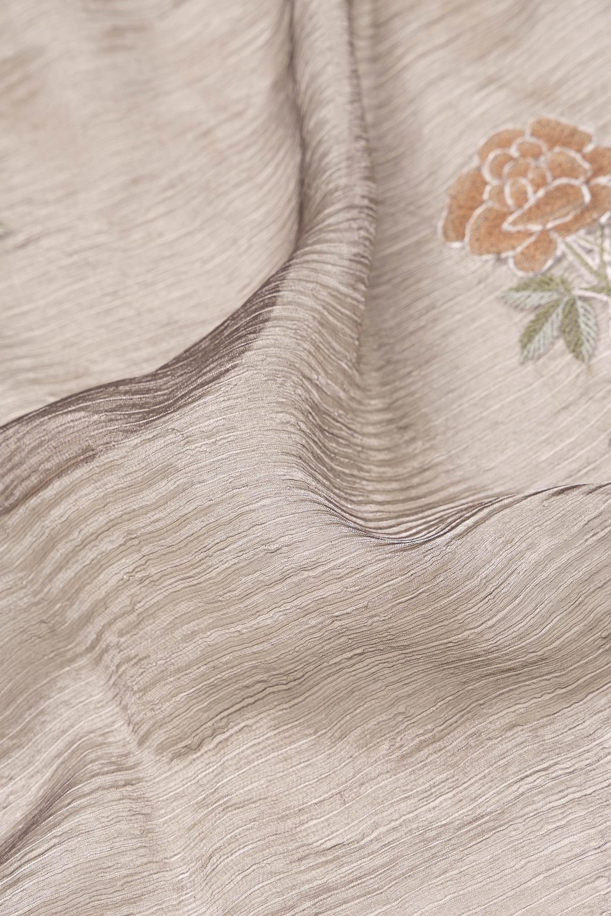 Close up of Brown Dual Tone Organza Silk Saree with Embroidery on the body and Zari Border.  displaying folds