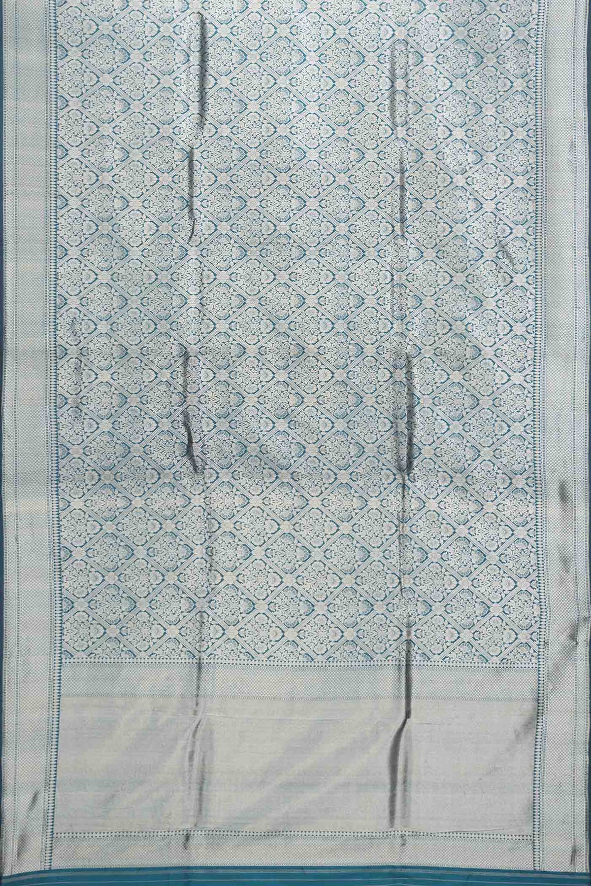 Flat view of Peacock Blue Dual Tone Banarasi Silk Saree with Zari Brocade on the body and Zari Border. 