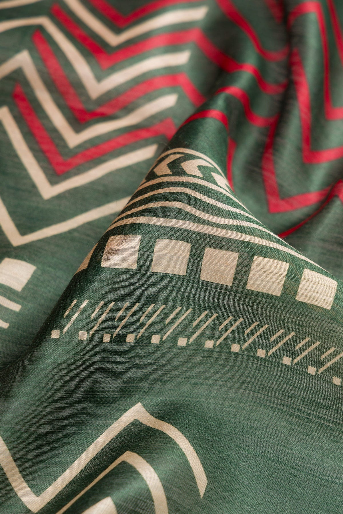 Close up of Green Dual Tone Tussar Silk Saree with Printed design on the body and Zari Border.  displaying folds