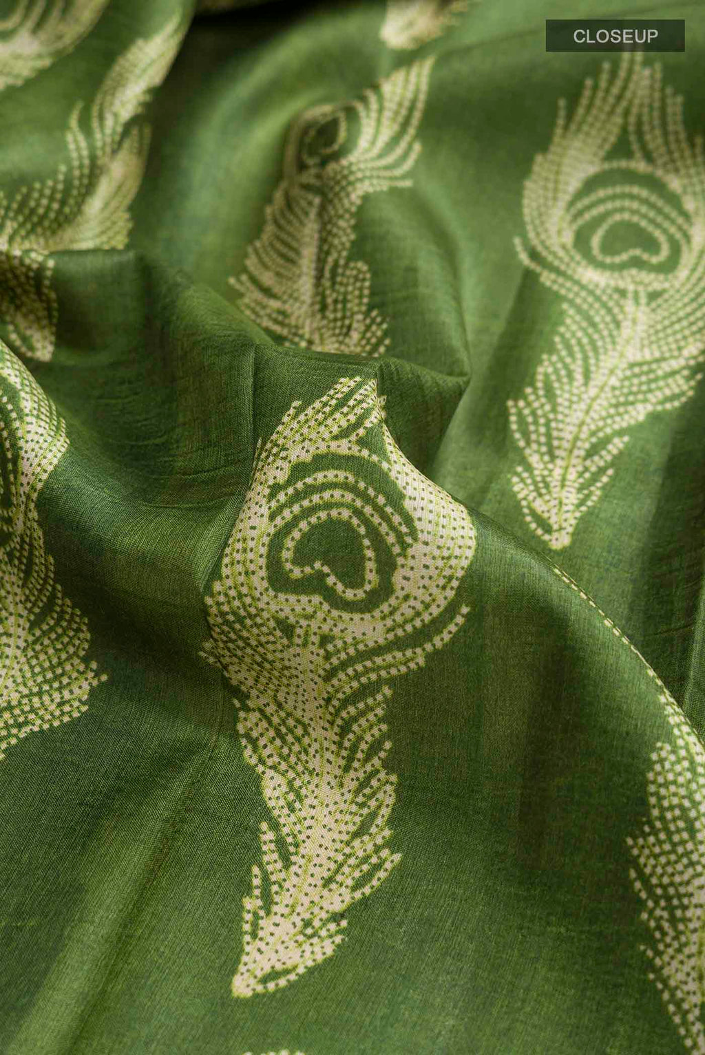 Close up of Green Tussar Silk Saree with Printed design on the body and Printed Border displaying folds
