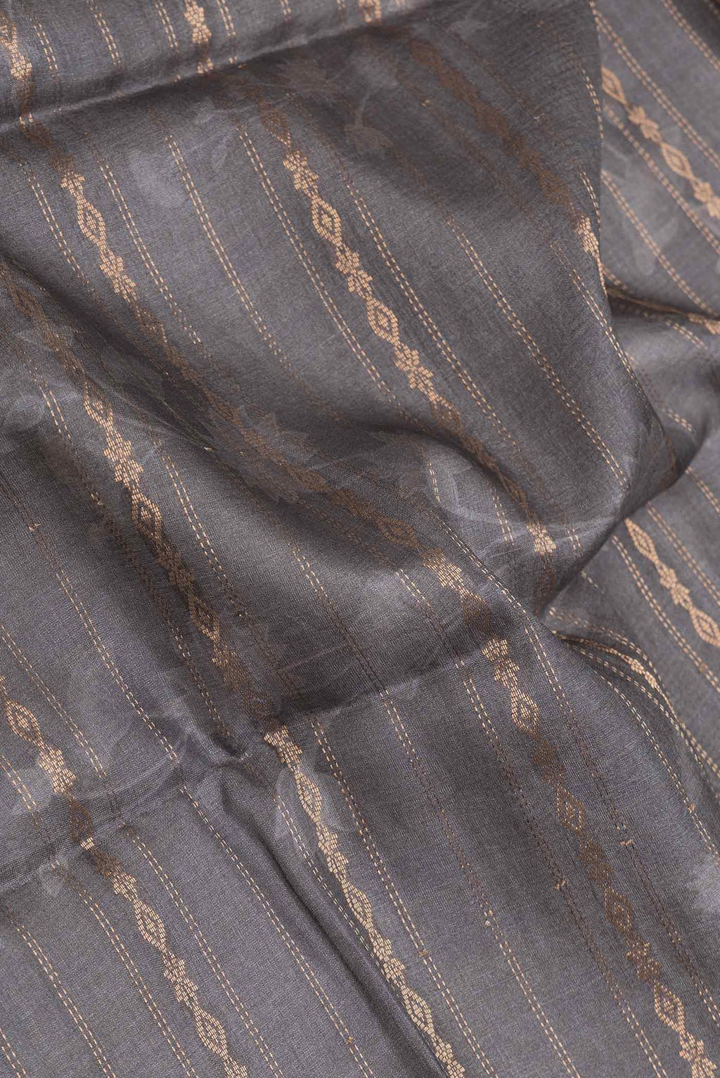 Close up of Grey Dual Tone Tussar Silk SareePrinted design on the body and Zari Border displaying folds