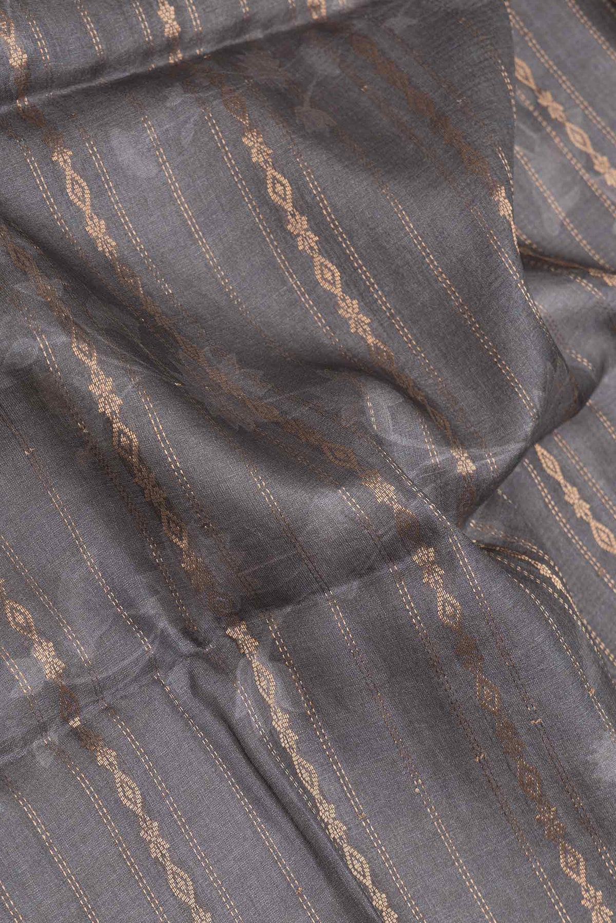 Close up of Grey Dual Tone Tussar Silk SareePrinted design on the body and Zari Border displaying folds