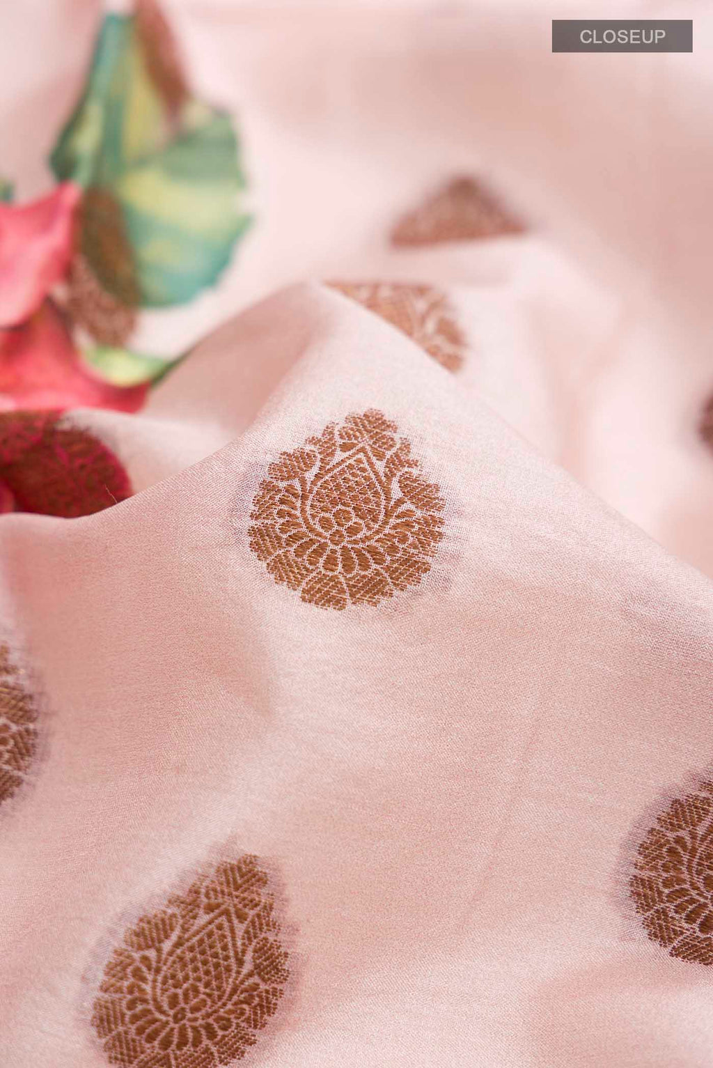 Close up of Rose pink Tussar Silk Saree with Printed design on the body and Zari Border displaying folds