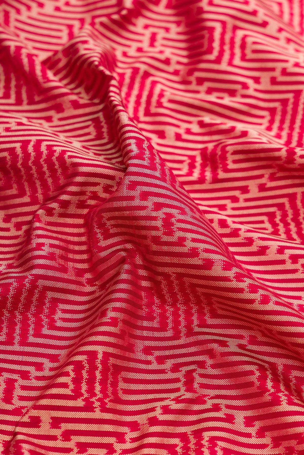 Close up of Maroon Dual Tone Double Ikat Saree with Ikat Print on the body and Thread Border.  displaying folds