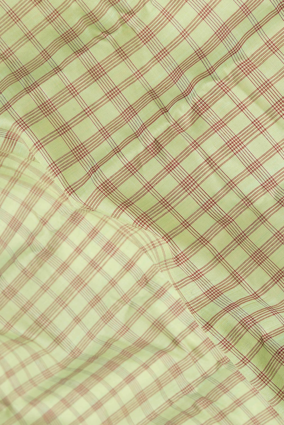 Close up of Pista Green Dual Tone Gadwal Silk Saree with Checked design on the body and Plain Border.  displaying folds