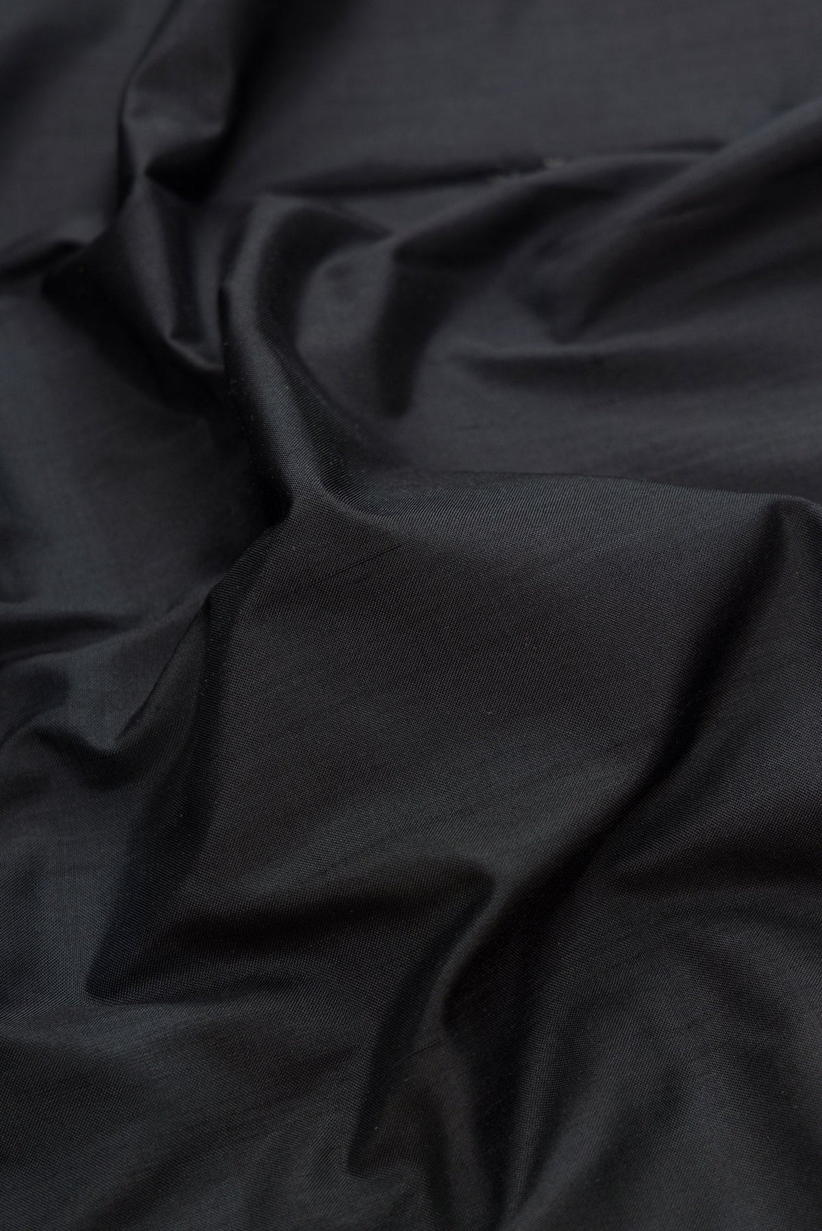 Close up of Black Dual Tone Double Ikat Saree with Plain Body and Temple Border.  displaying folds