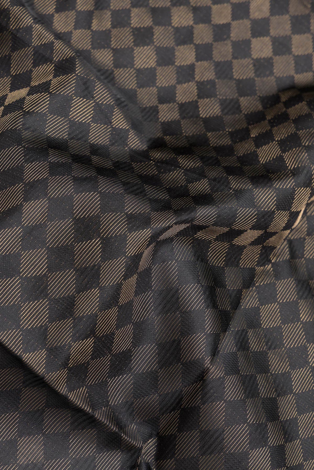 Close up of Black Dual Tone Soft Silk Saree with Zari Brocade on the body and Zari Border.  displaying folds