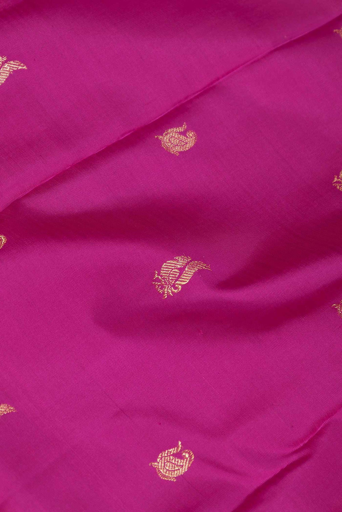 Close up of Magenta Dual Tone Kanchipuram Saree with Zari Butta on the body and Zari Border displaying folds