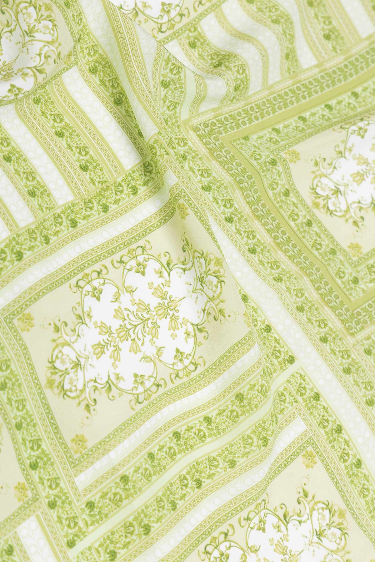 Close up of Pista Green Dual Tone Mysore Crepe Saree with Printed design on the body and Printed Border displaying folds
