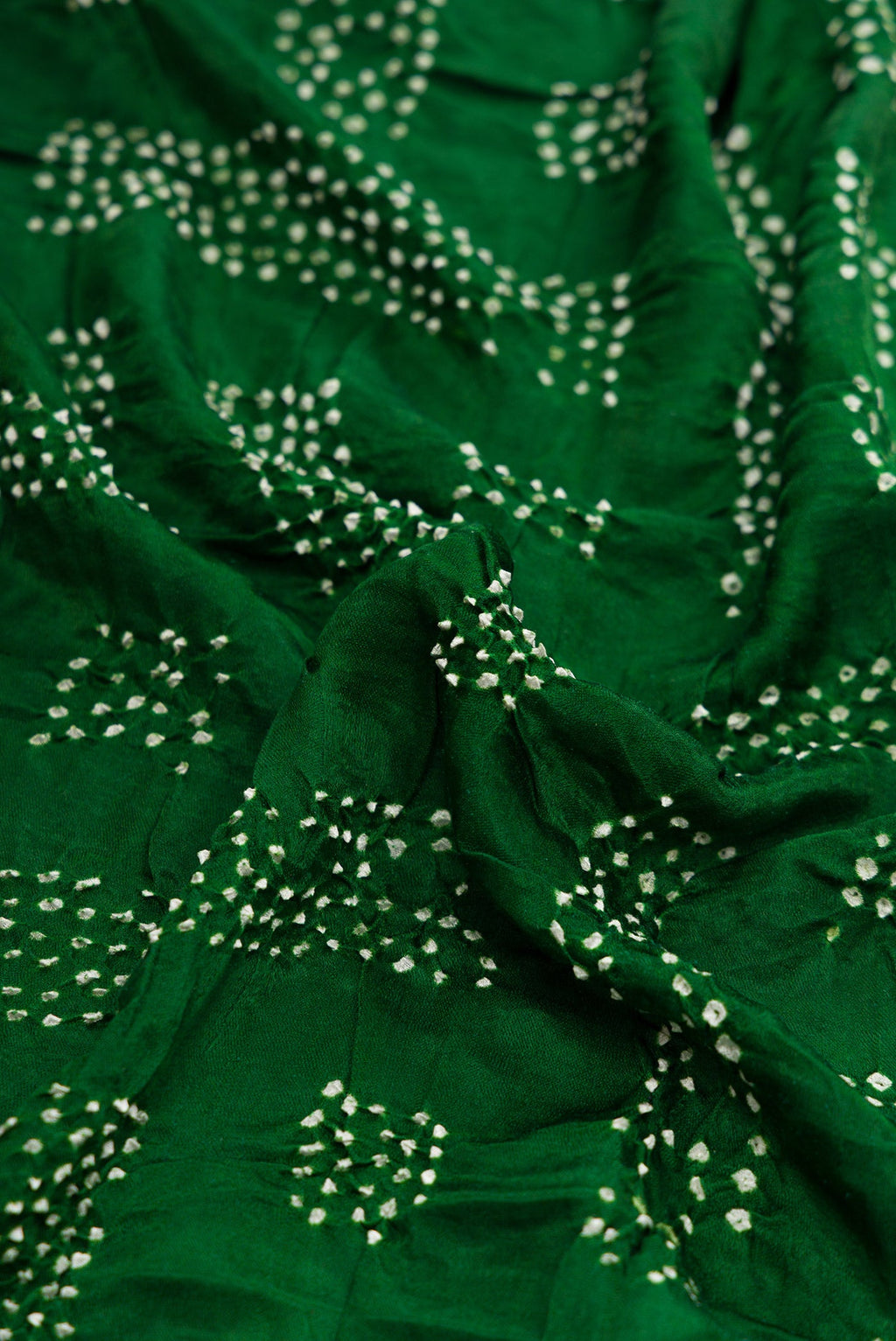 Close up of Bottle Green Dual Tone Bandhani Silk Saree with Printed design on the body and Printed Border.  displaying folds