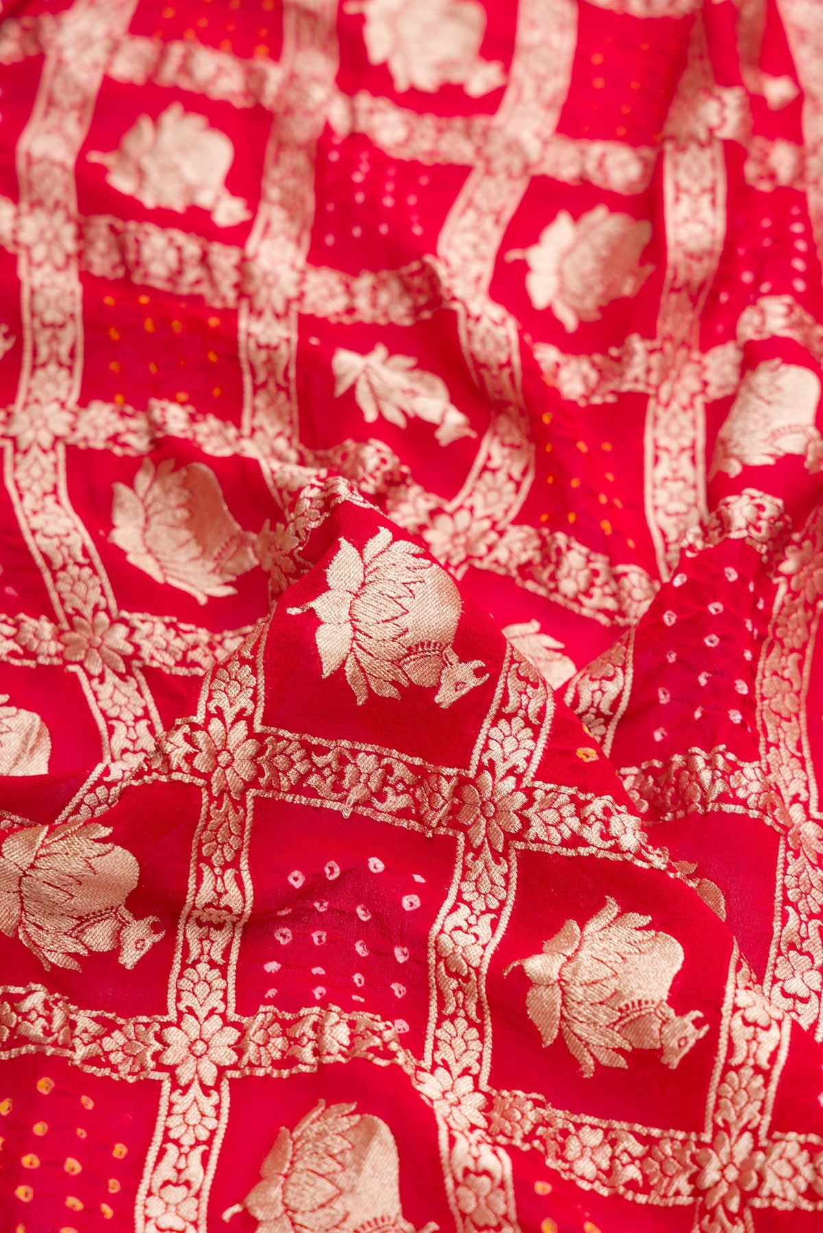 Close up of Red Dual Tone Bandhani Silk Saree with Zari Brocade on the body and Zari Border.  displaying folds