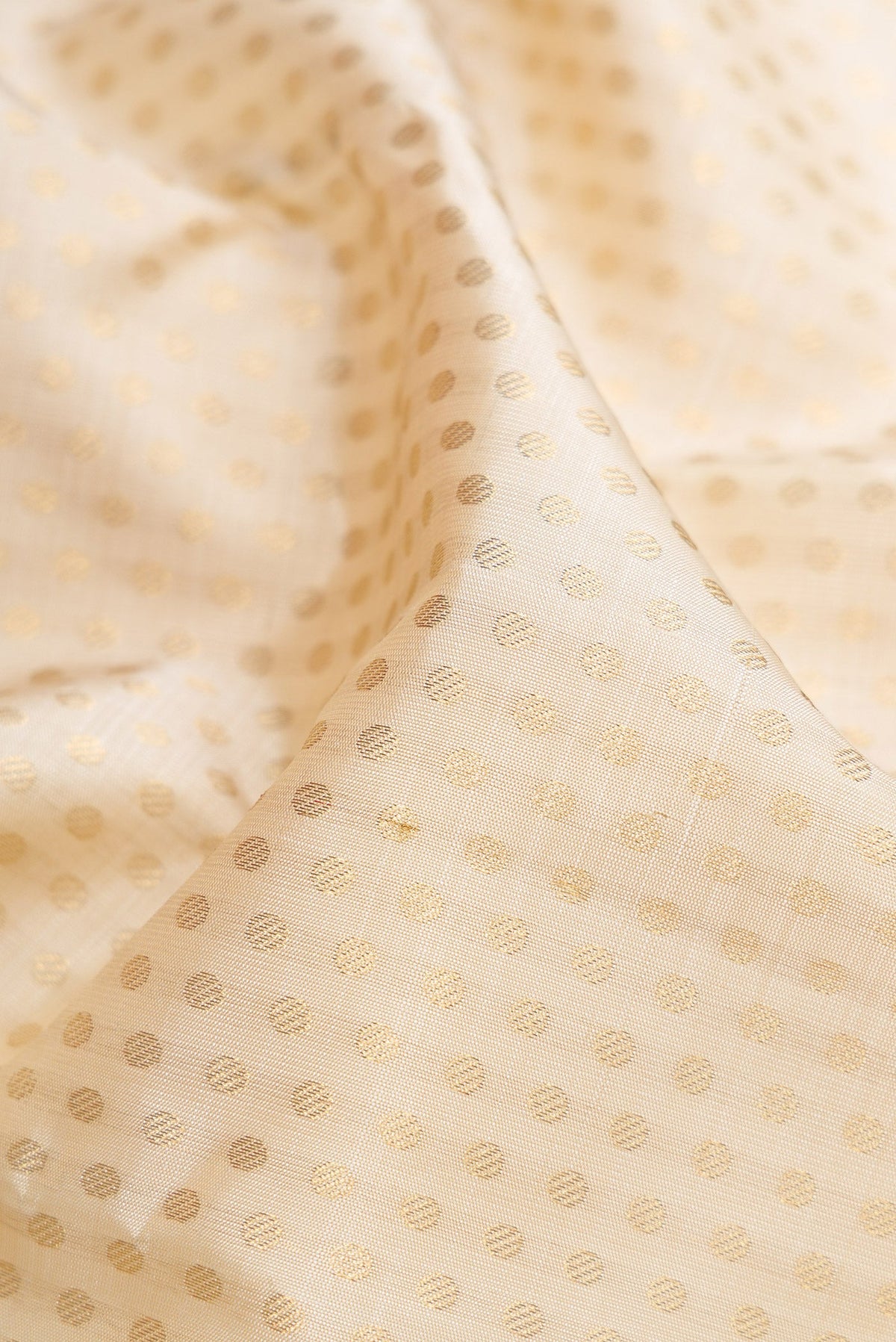 Close up of Pure Silk Pure Zari Off White Dual Tone Kanjivaram Saree with Zari Brocade on the body and Zari Border.  displaying folds