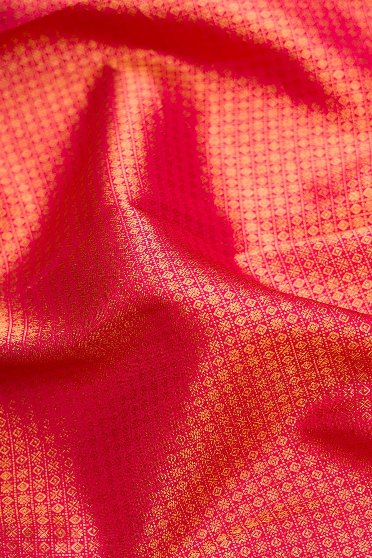Close up of Red Dual Tone Kanjivaram Silk Saree with Zari Brocade on the body and Zari Border.  displaying folds