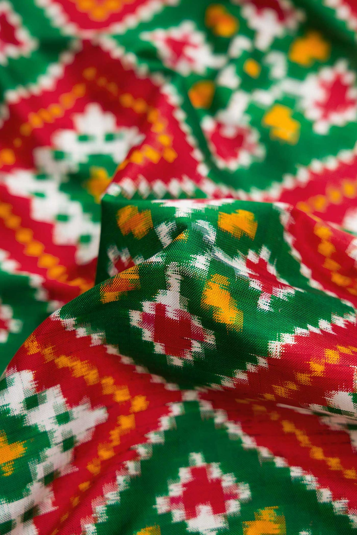 Close up of Green Pochampally Silk Saree with Pure Ikat on the body and Zari Border displaying folds