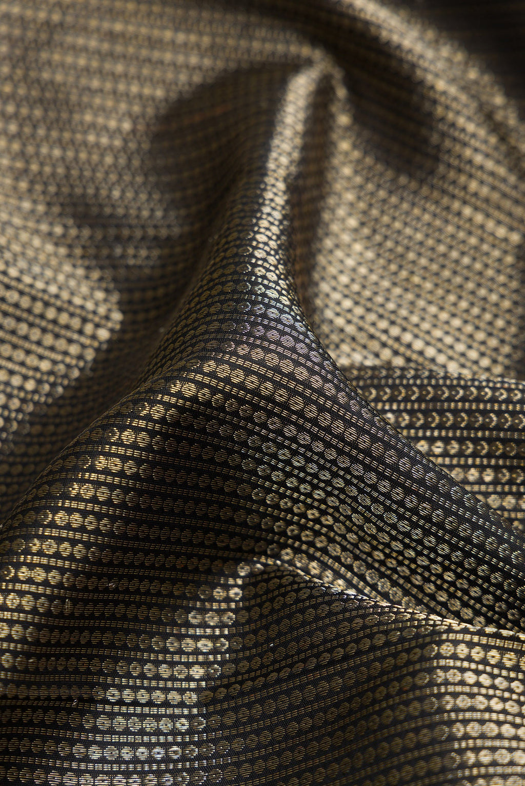 Close up of Black Kanchipuram Silk Saree with Zari Brocade on the body and Zari Border.  displaying folds