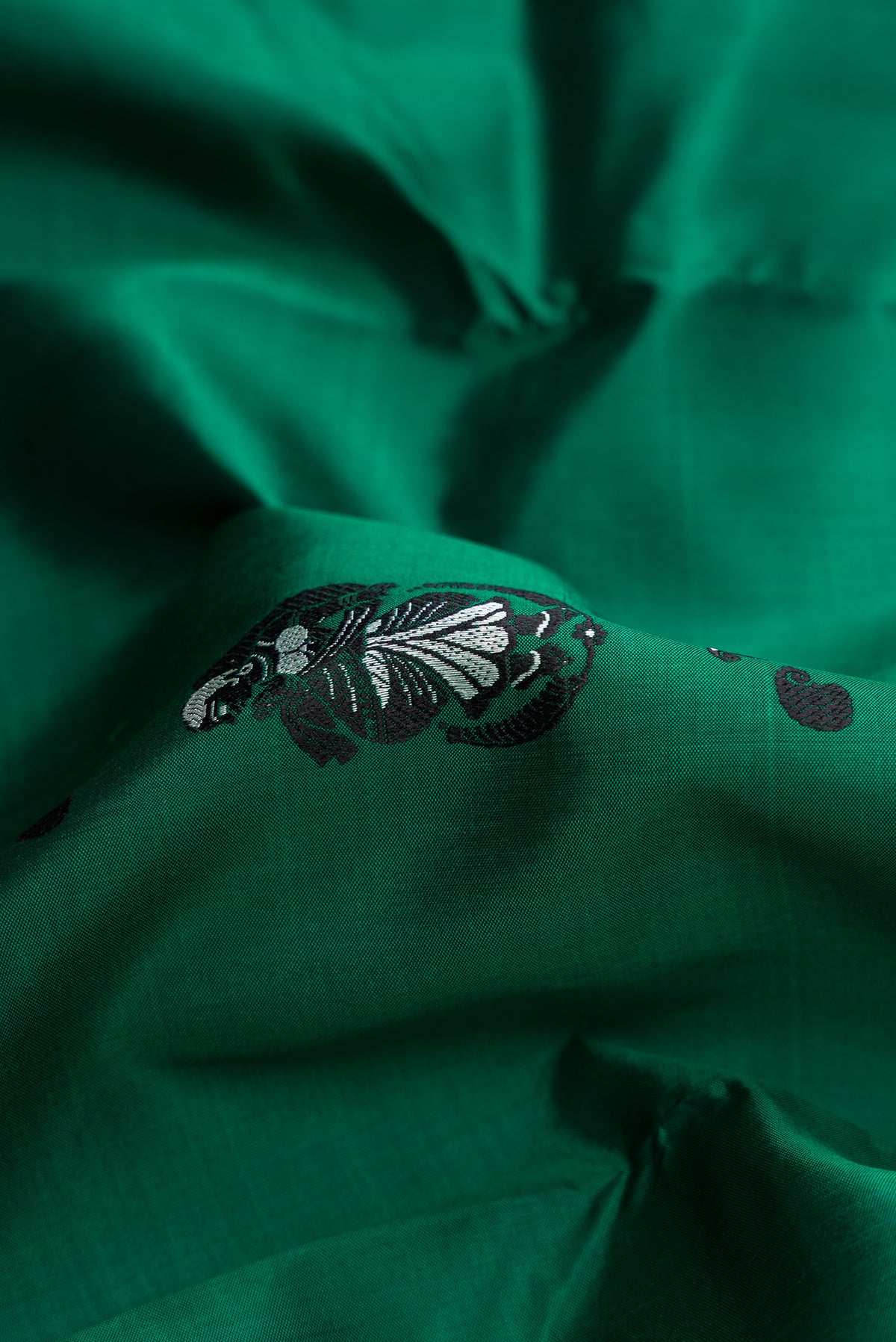 Close up of Bottle Green Baluchari Silk Saree with Thread Butta on the body and Thread Border.  displaying folds
