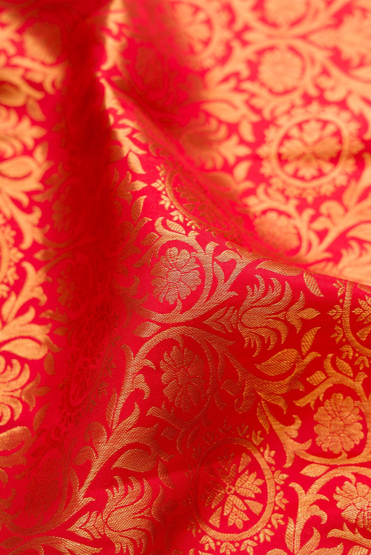 Close up of Red Dual Tone Kanjivaram Silk Saree with Zari Brocade on the body and Zari Border.  displaying folds