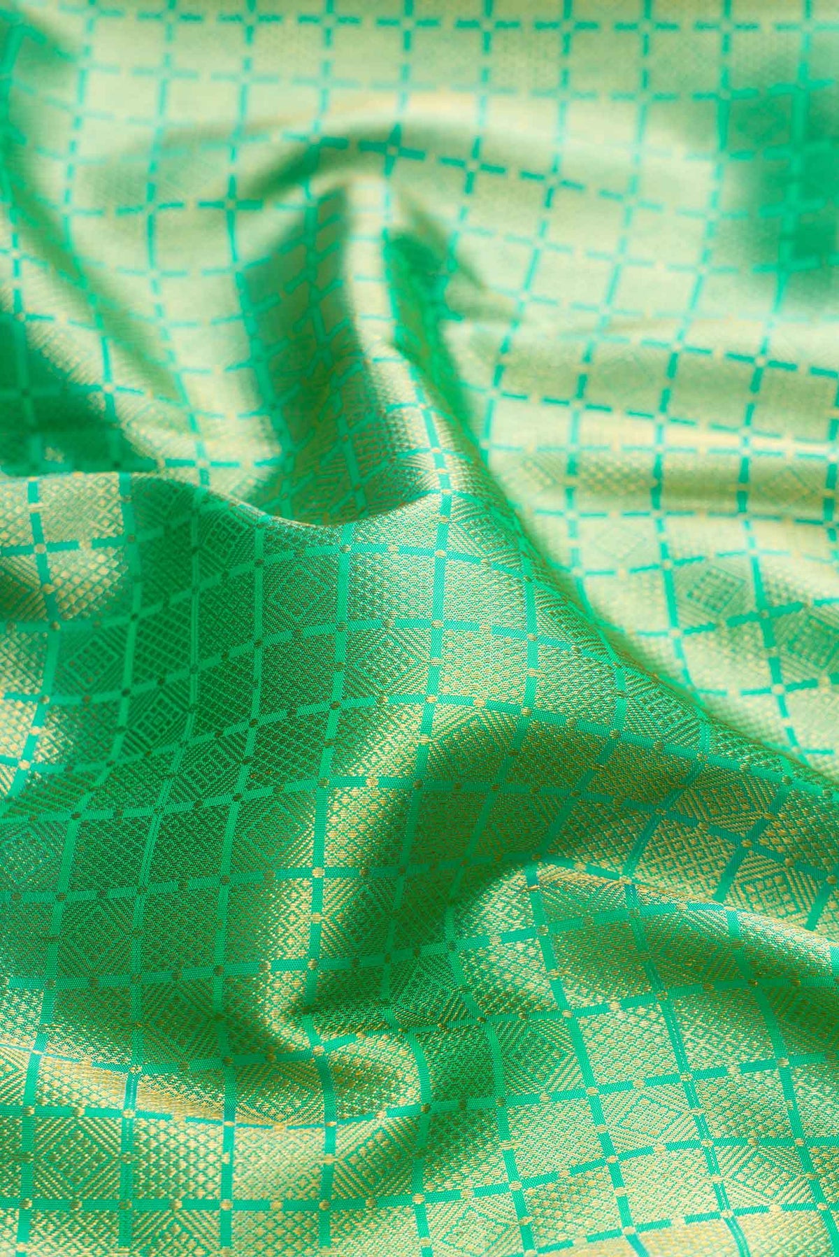 Close up of Green Dual Tone Kanjivaram Silk Saree with Zari Brocade on the body and Zari Border.  displaying folds