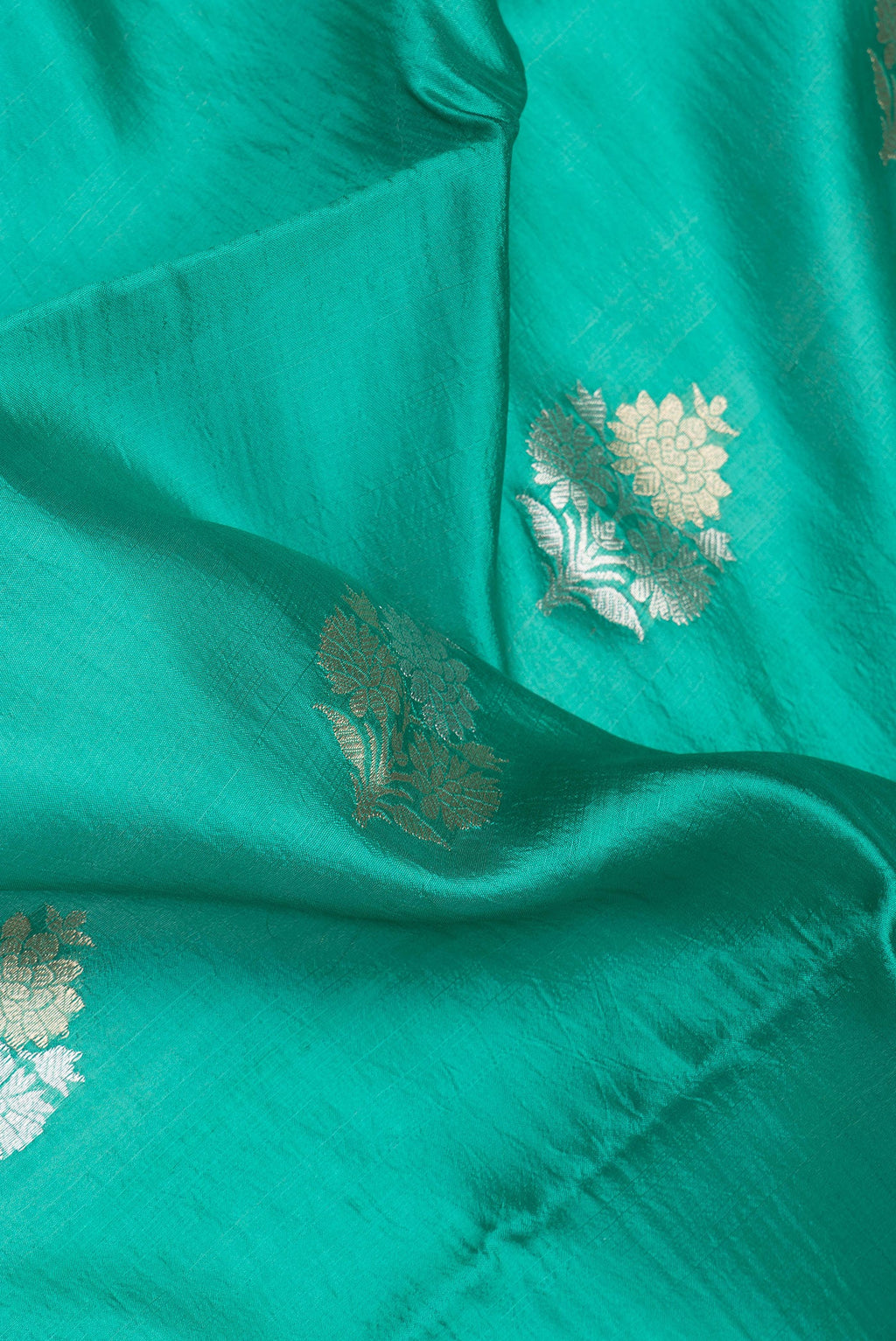 Close up of Green Dual Tone Banarasi Raw Silk Saree with Zari Butta on the body and Without Border.  displaying folds