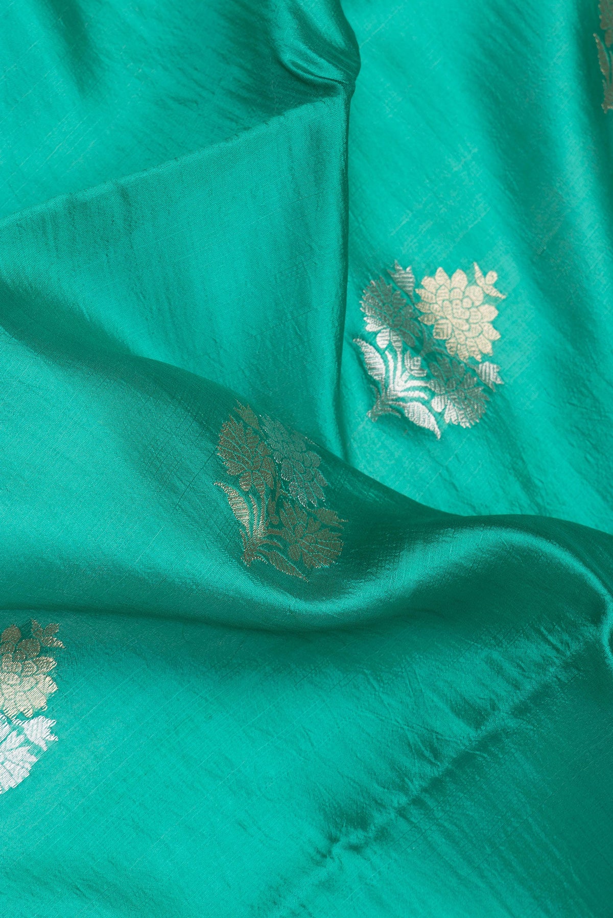 Close up of Green Dual Tone Banarasi Raw Silk Saree with Zari Butta on the body and Without Border.  displaying folds
