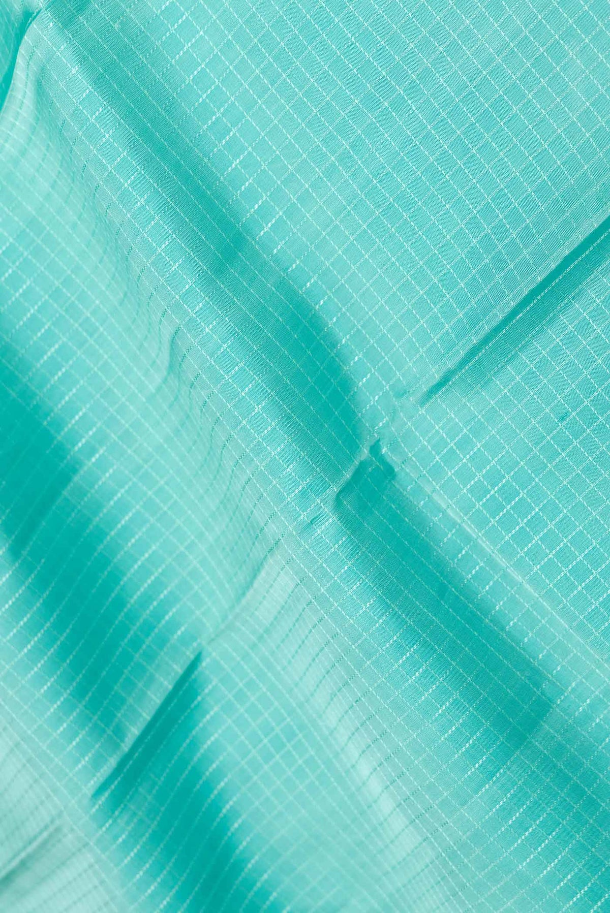 Close up of Sea Green Dual Tone Kanchipuram Saree with Checked design on the body and Zari Border displaying folds