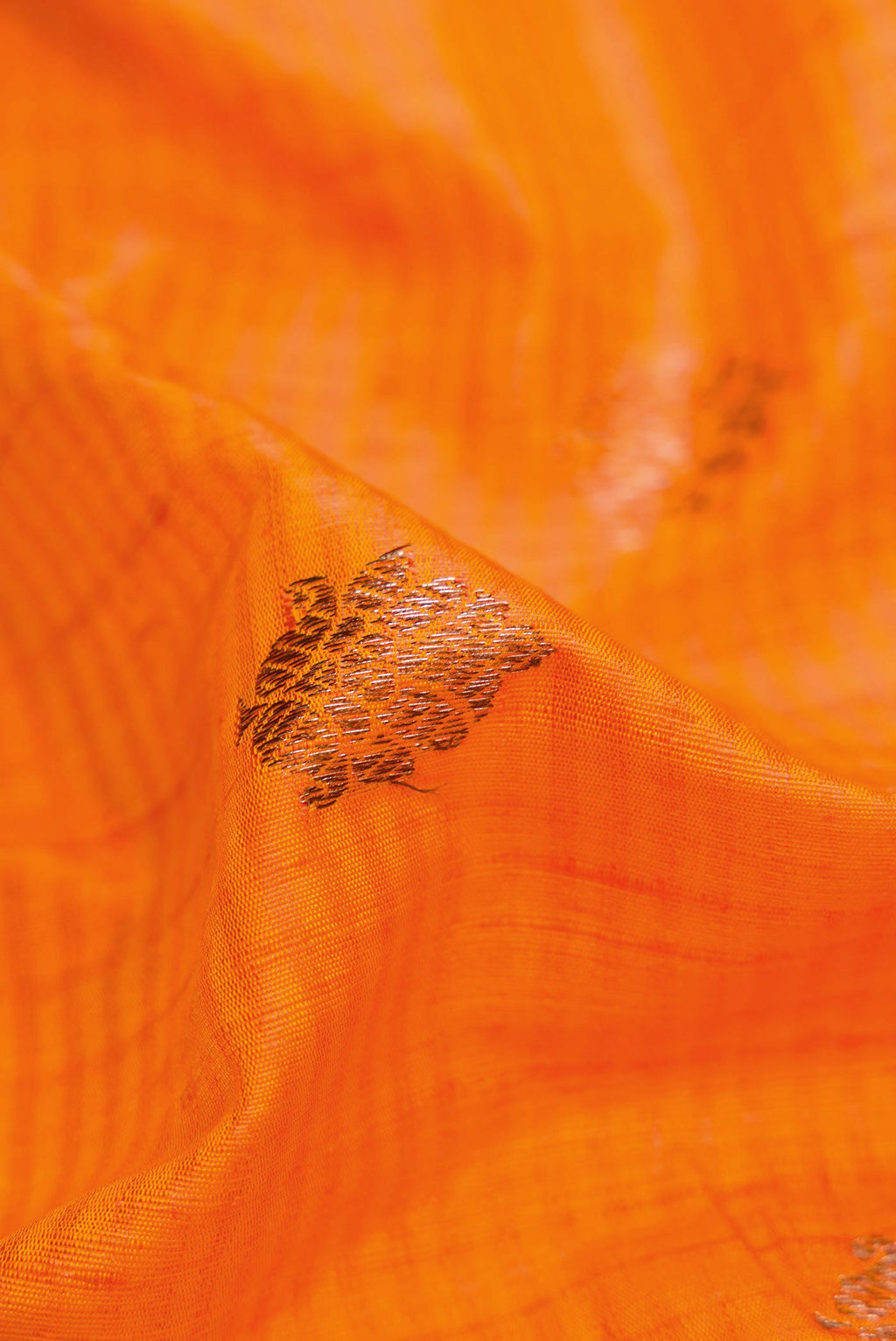 Close up of Orange Banarasi Tussar Silk Saree with Zari Butta on the body and Zari Border displaying folds