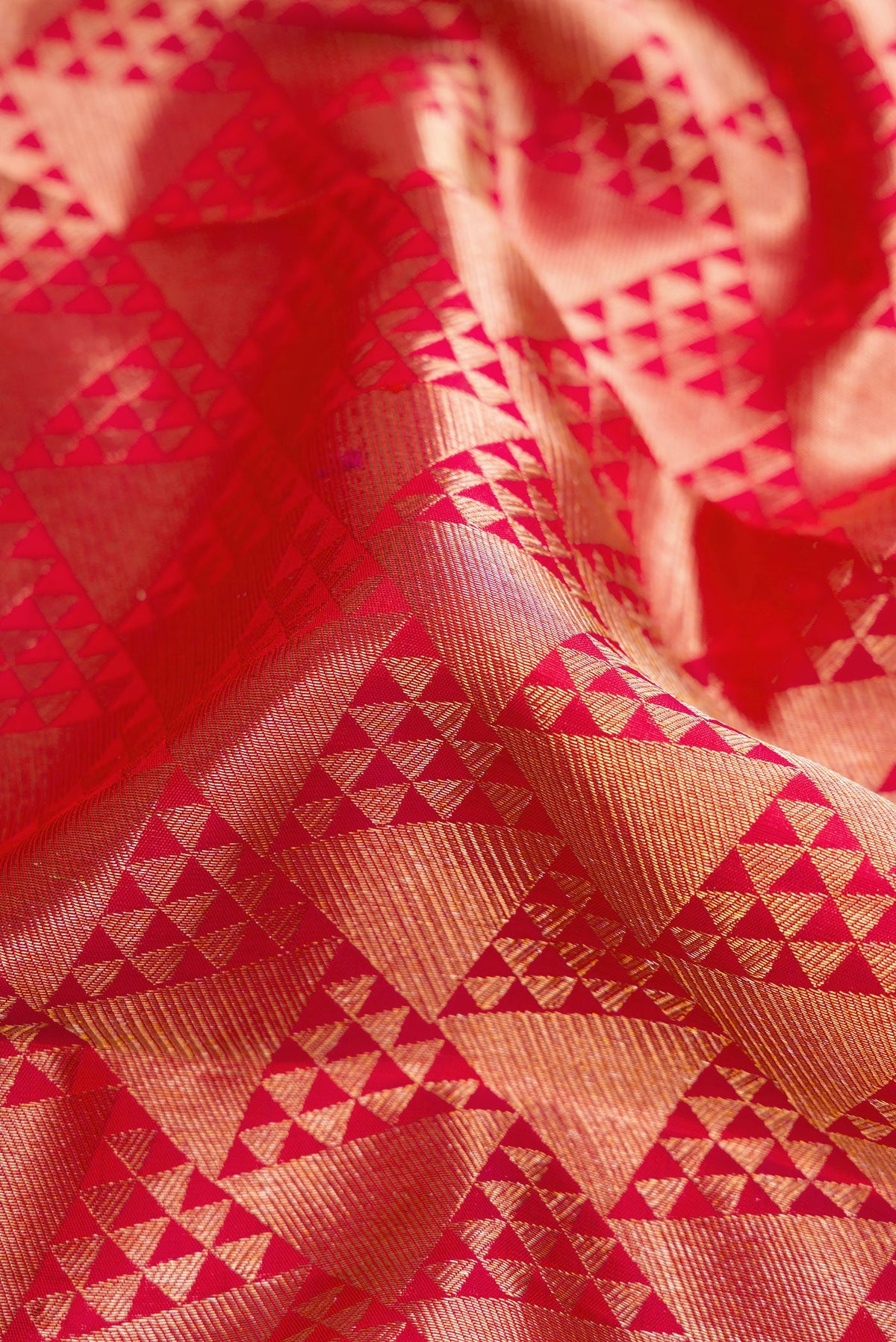 Close up of Red Dual Tone Kanchipuram Silk Saree with Zari Brocade on the body and Zari Border.  displaying folds