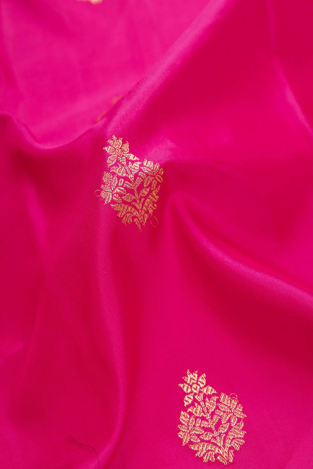 Close up of Dark Pink Dual Tone Kanchipuram Silk Saree with Zari Butta on the body and Zari Border displaying folds