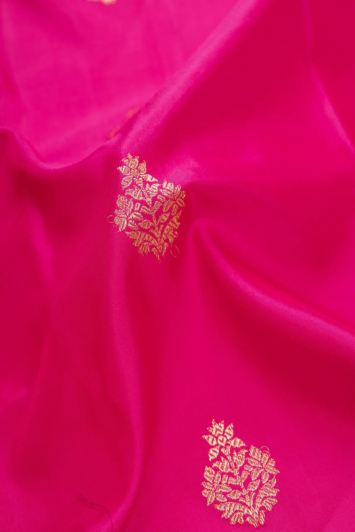 Close up of Dark Pink Dual Tone Kanchipuram Silk Saree with Zari Butta on the body and Zari Border displaying folds