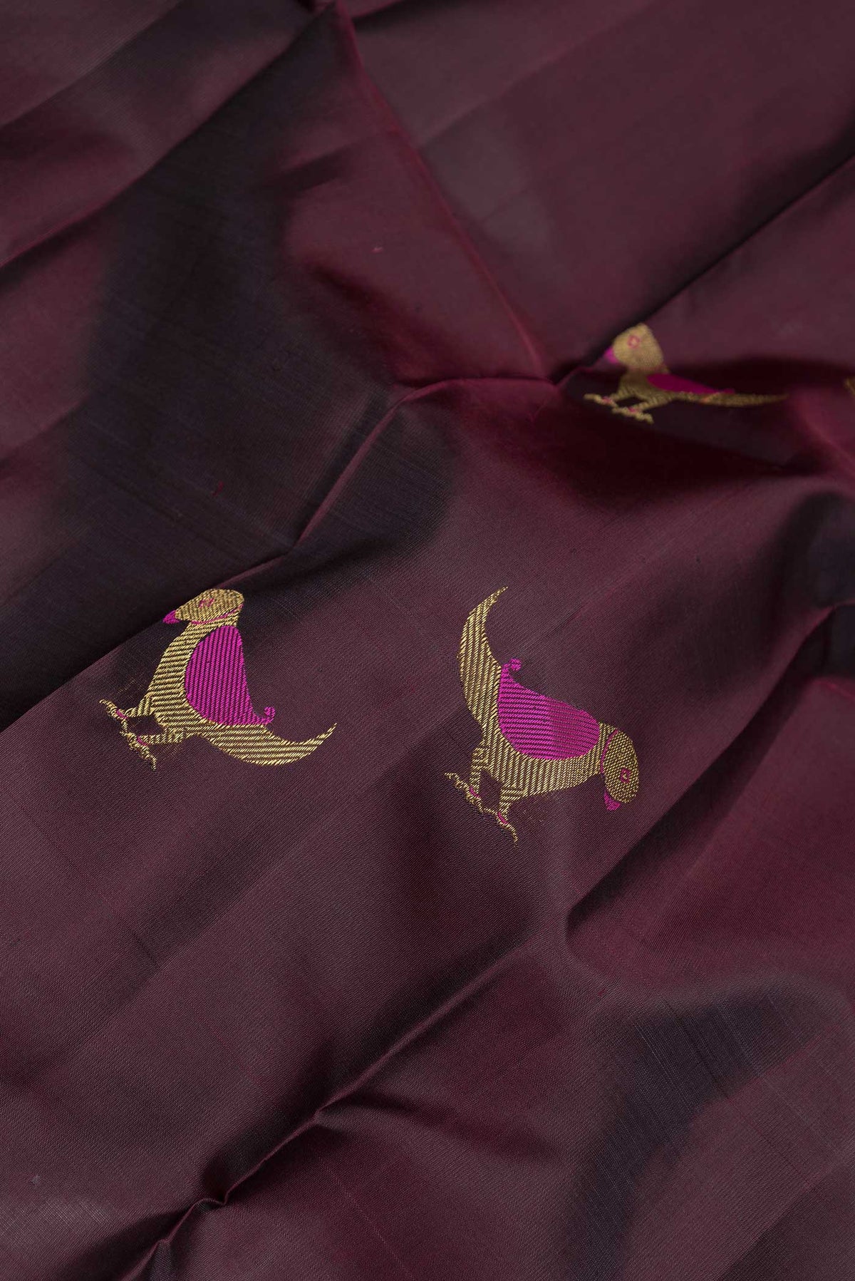 Close up of Pure Silk Pure Zari Coffee Brown Dual Tone Kanchipuram Saree with Zari And Thread Butta on the body and Zari Border displaying folds