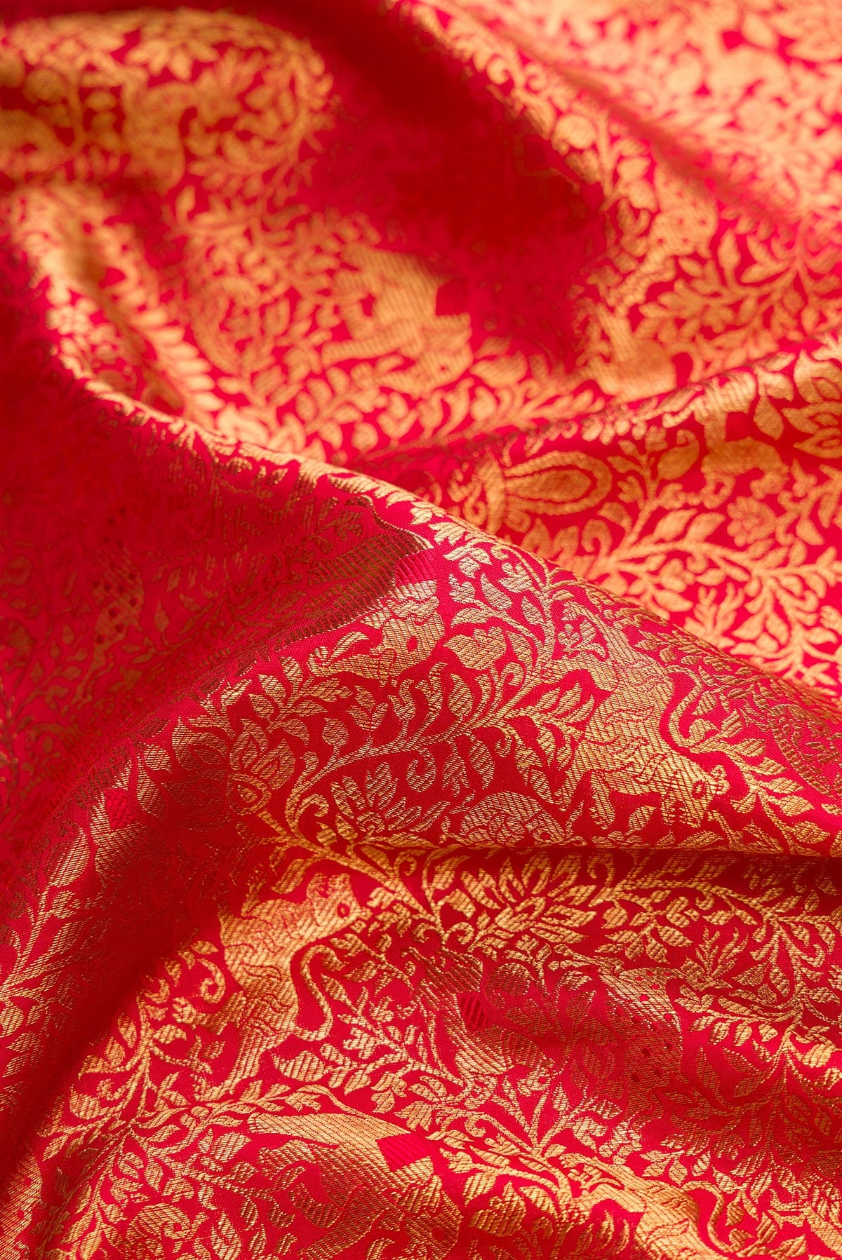 Close up of Pure Silk Pure Zari Red Dual Tone Kanjivaram Saree with Zari Brocade on the body and Zari Border.  displaying folds