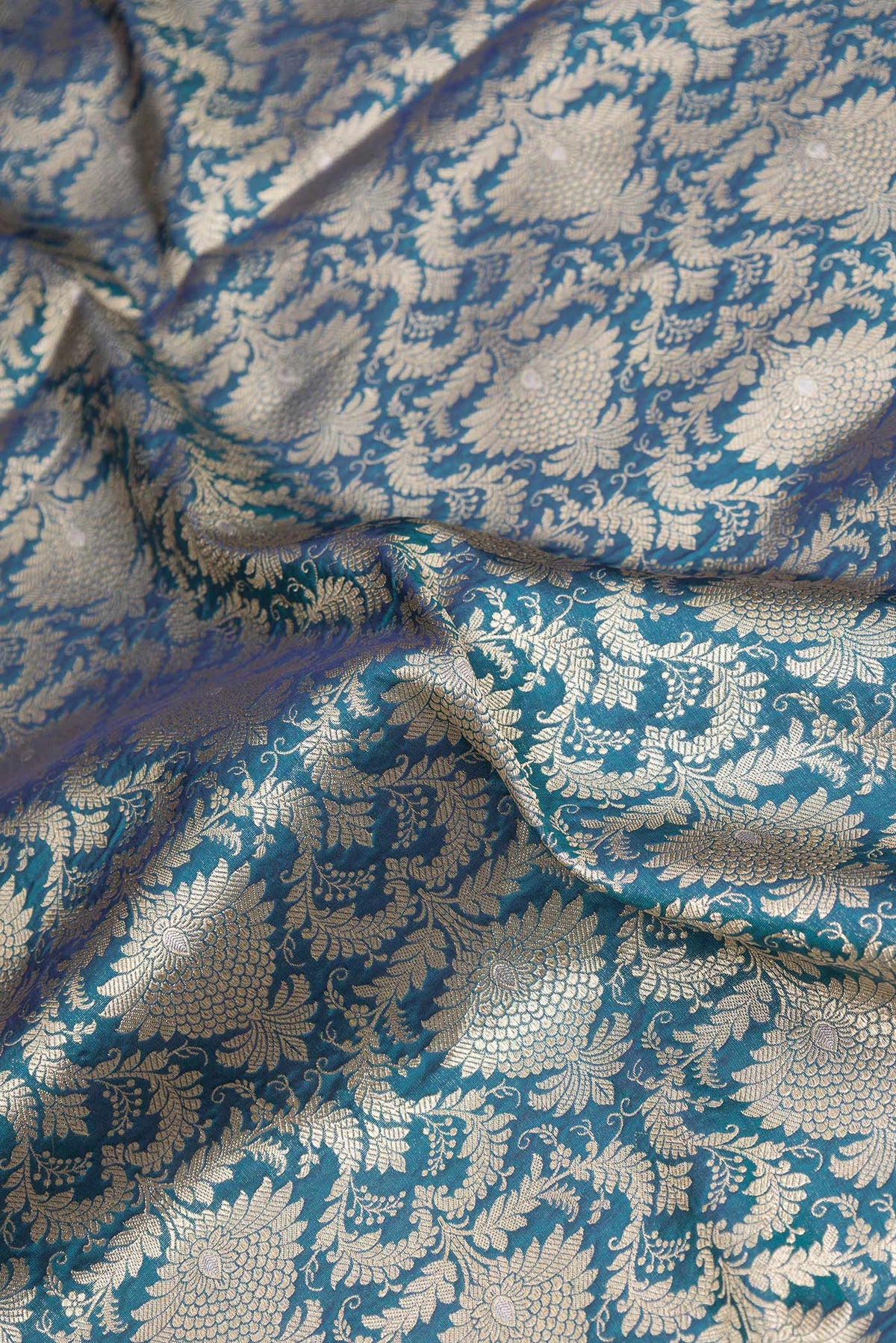 Close up of Peacock Blue Dual Tone Banarasi Silk Saree with Zari Brocade on the body and Zari Border.  displaying folds