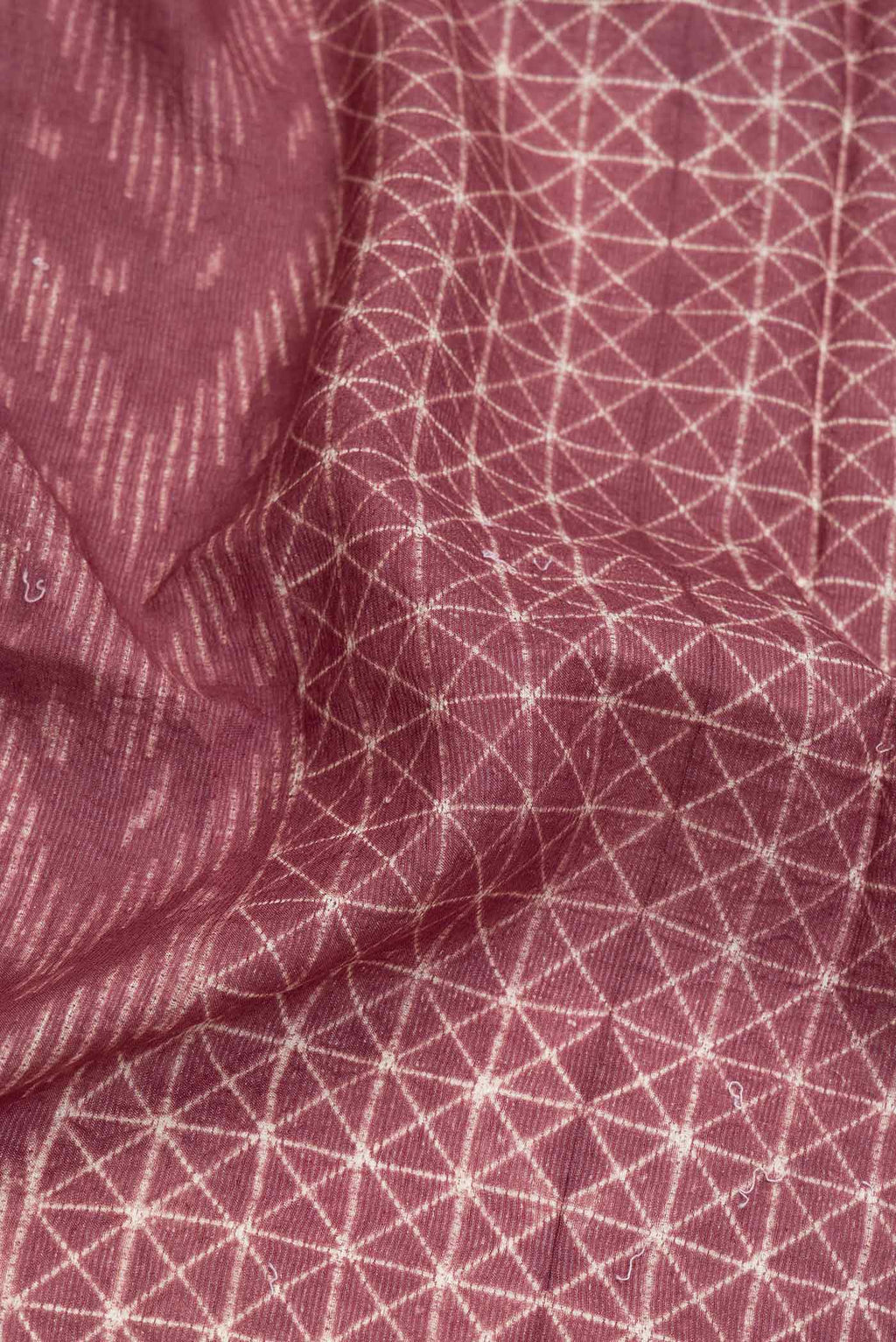 Close up of Brown Dual Tone Tussar Saree with Printed design on the body and Zari Border.  displaying folds