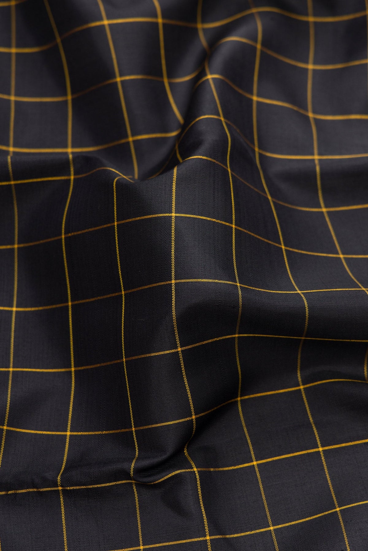 Close up of Black Dual Tone Kanchipuram Silk Saree with Checked design on the body and Temple Border.  displaying folds