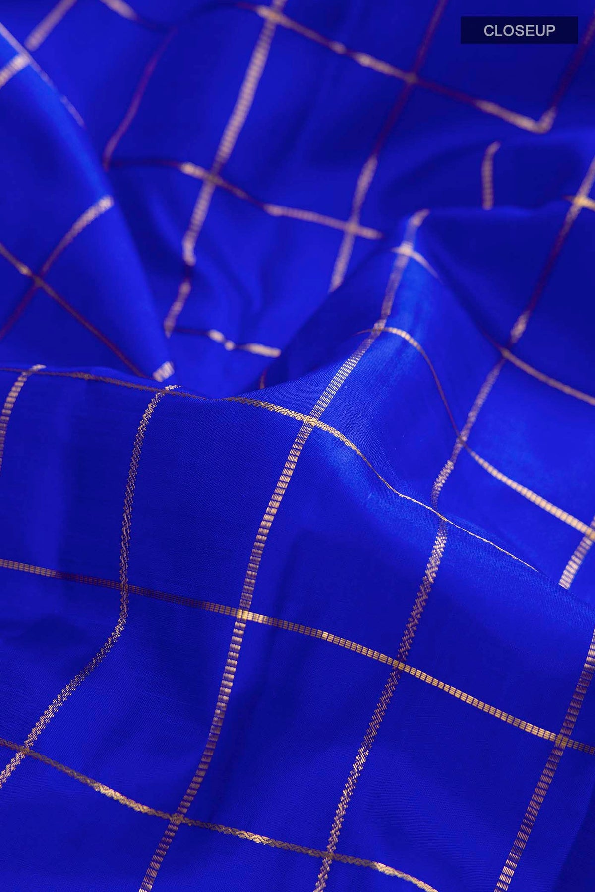 Close up of Blue Kanchipuram Silk Saree with Checked design on the body and Zari Border displaying folds