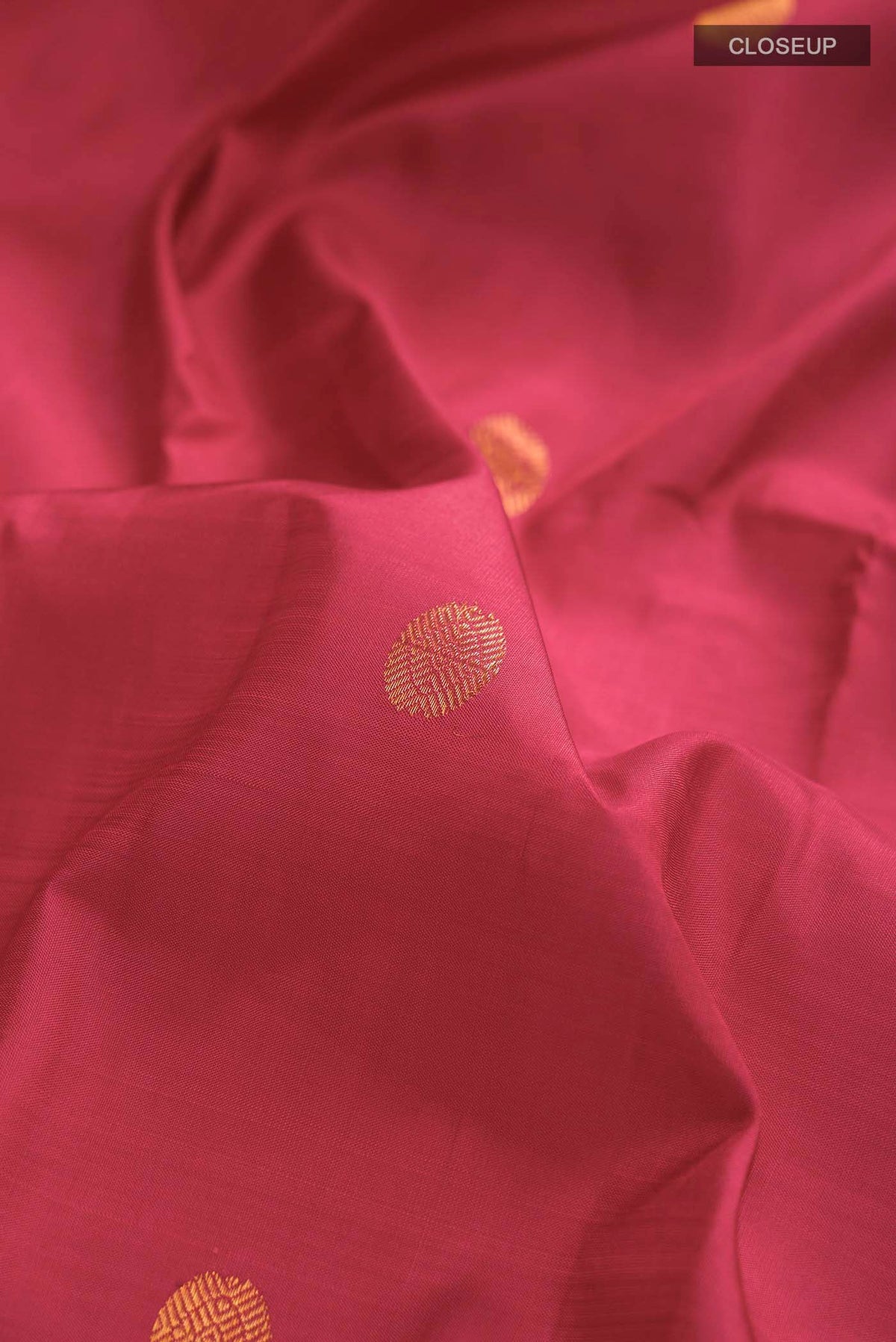 Close up of Pink Kanchipuram Silk Saree with Zari Butta on the body and Zari Border displaying folds