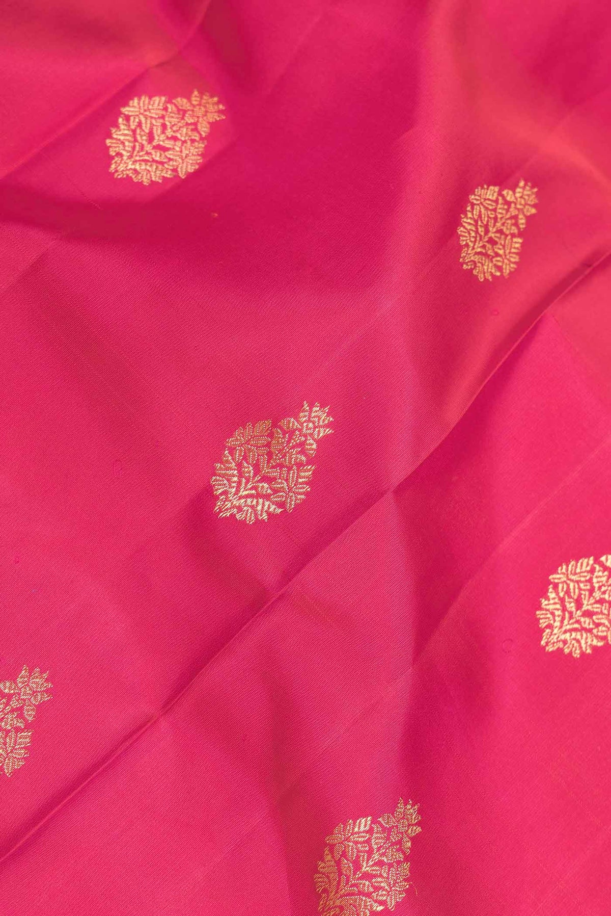 Close up of Dark Pink Dual Tone Kanchipuram Silk Saree with Zari Butta on the body and Zari Border displaying folds