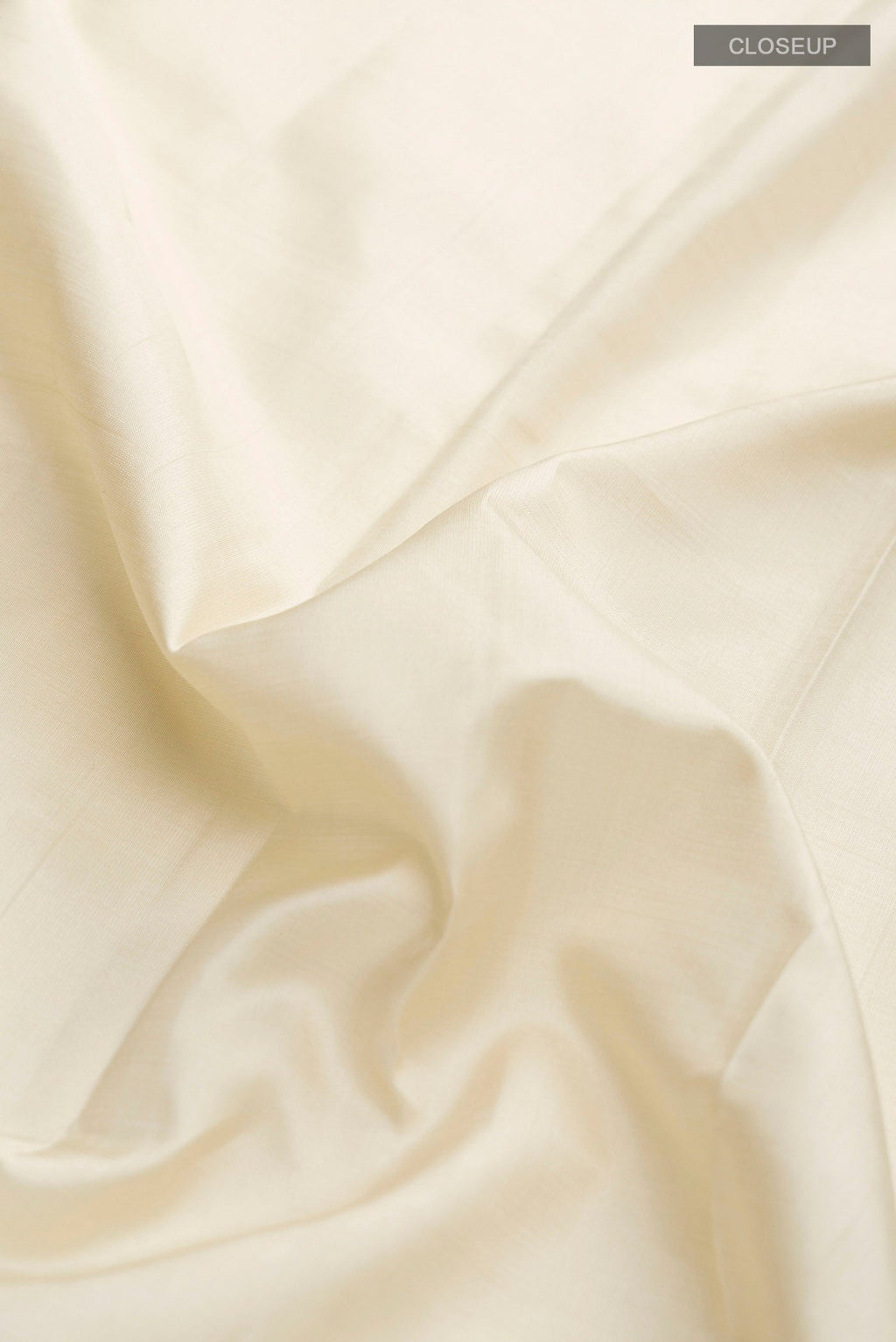 Close up of Cream Kanchipuram Silk Saree with Plain Body and Temple Border displaying folds