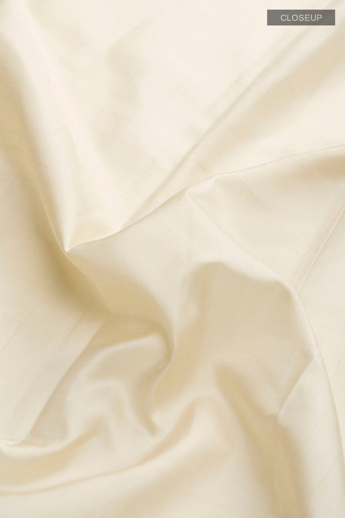 Close up of Cream Kanchipuram Silk Saree with Plain Body and Temple Border displaying folds