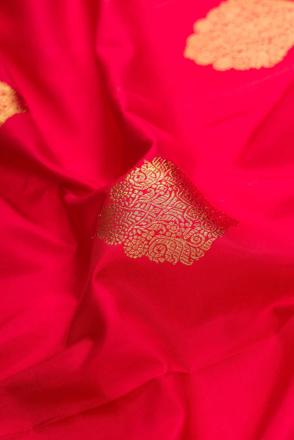 Close up of Pure Silk Pure Zari Red Dual Tone Kanjivaram Saree with Zari Butta on the body and Fancy Border.  displaying folds