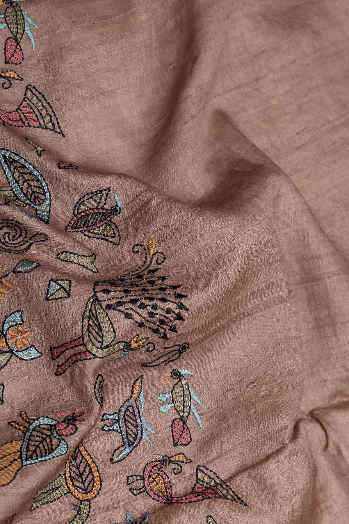 Close up of Brown Dual Tone Tussar Silk Saree with Embroidery on the body and Embroidery Border displaying folds