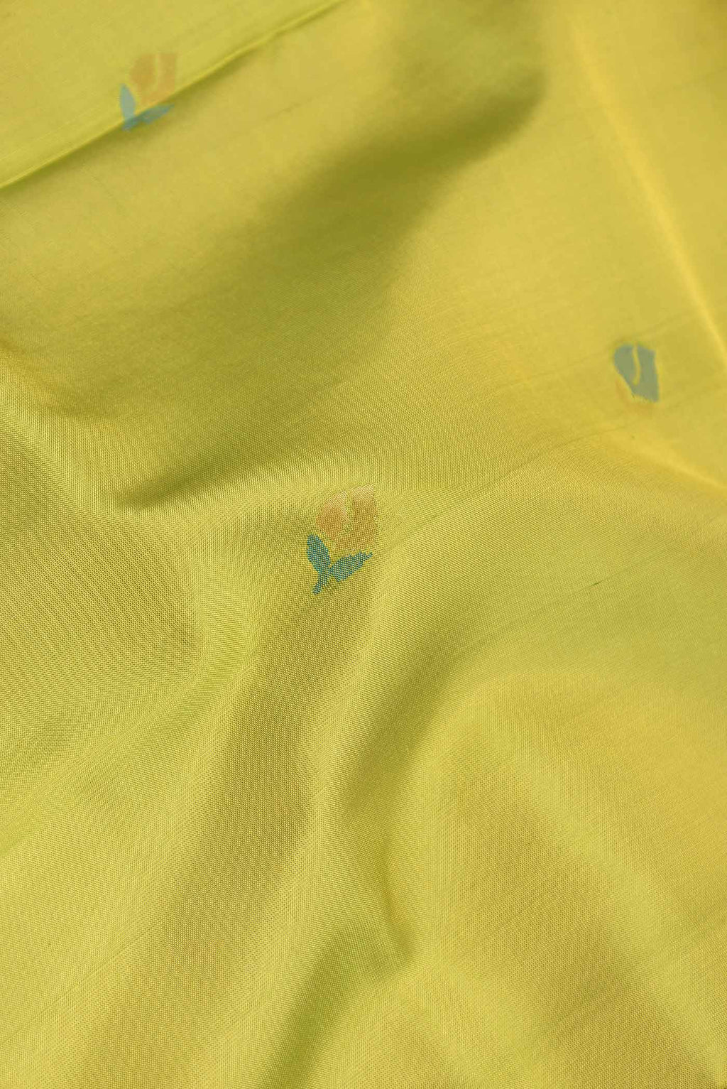 Close up of Parrot Green Dual Tone Uppada Silk Saree with Zari And Thread Butta on the body and Zari Border displaying folds