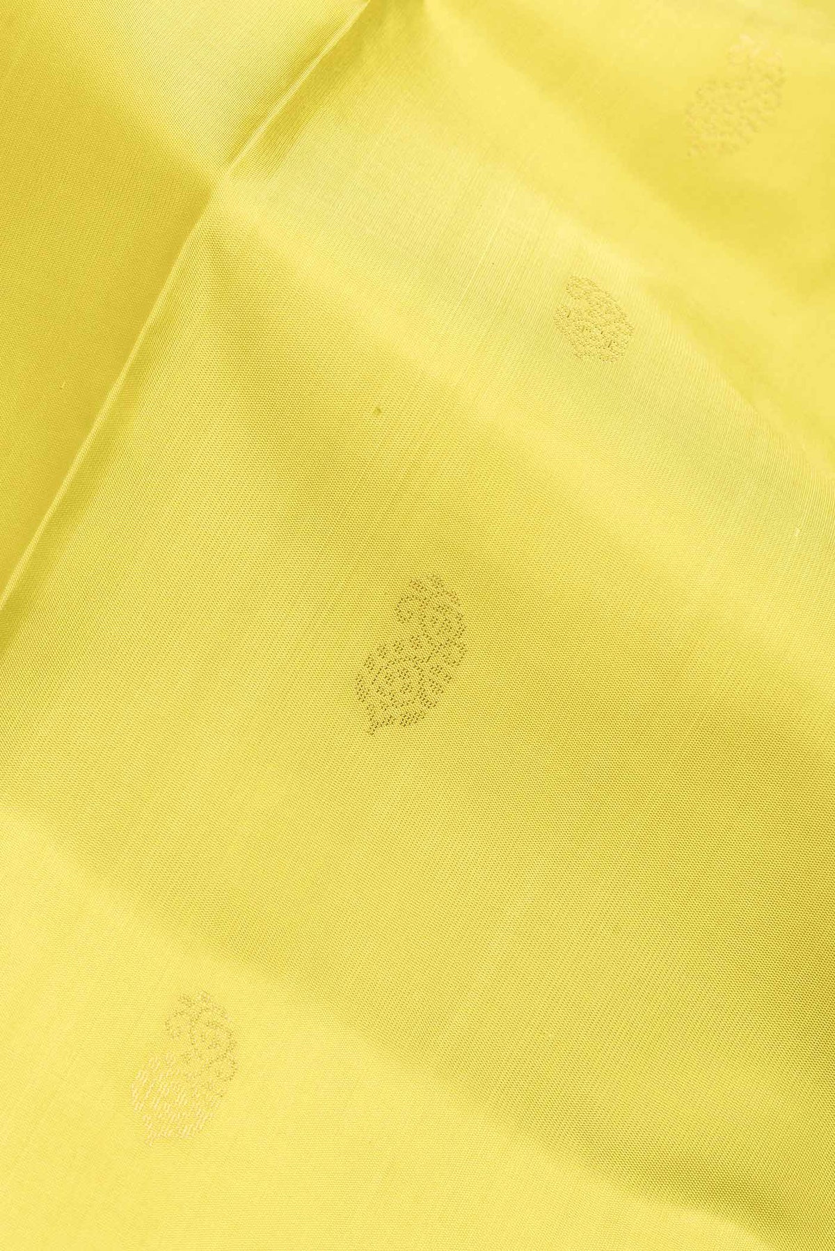 Close up of Lemon Yellow Dual Tone Soft Silk Saree with Zari Butta on the body and Fancy Border.  displaying folds