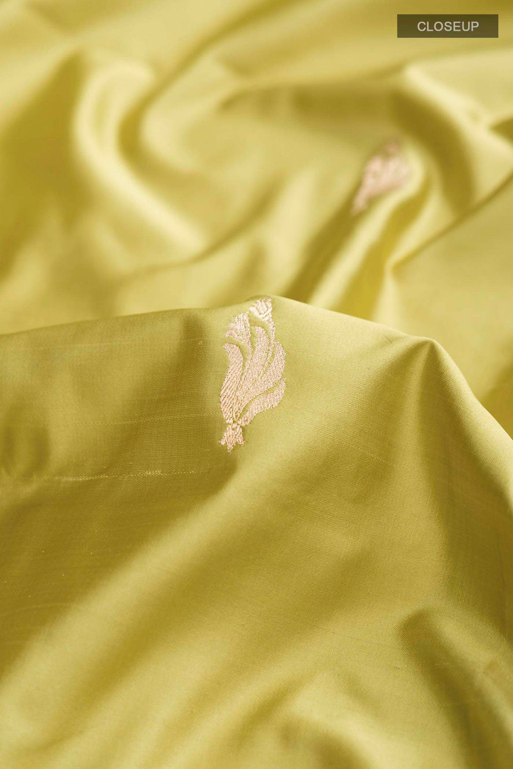 Close up of Green Banarasi Silk Saree with Zari Butta on the body and Zari Border displaying folds