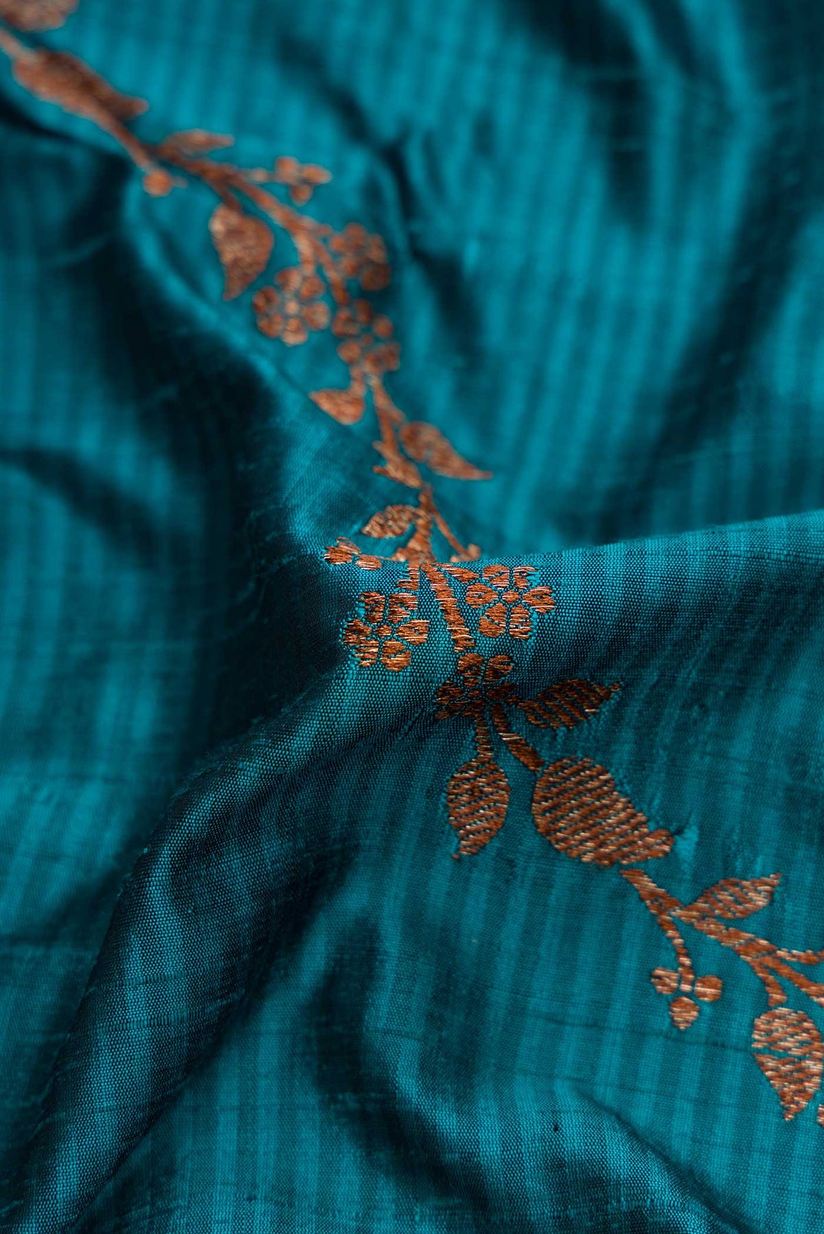Close up of Maya Blue Banarasi Tussar Silk Saree with Zari Butta on the body and Zari Border displaying folds