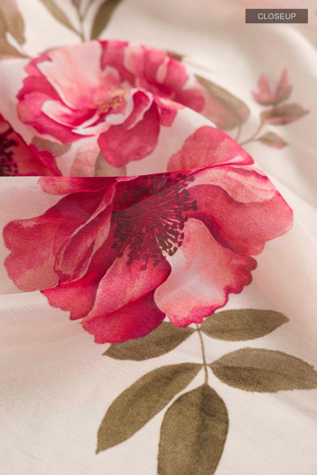 Close up of Cream Crepe SareePrinted design on the body and Embroidery Border displaying folds